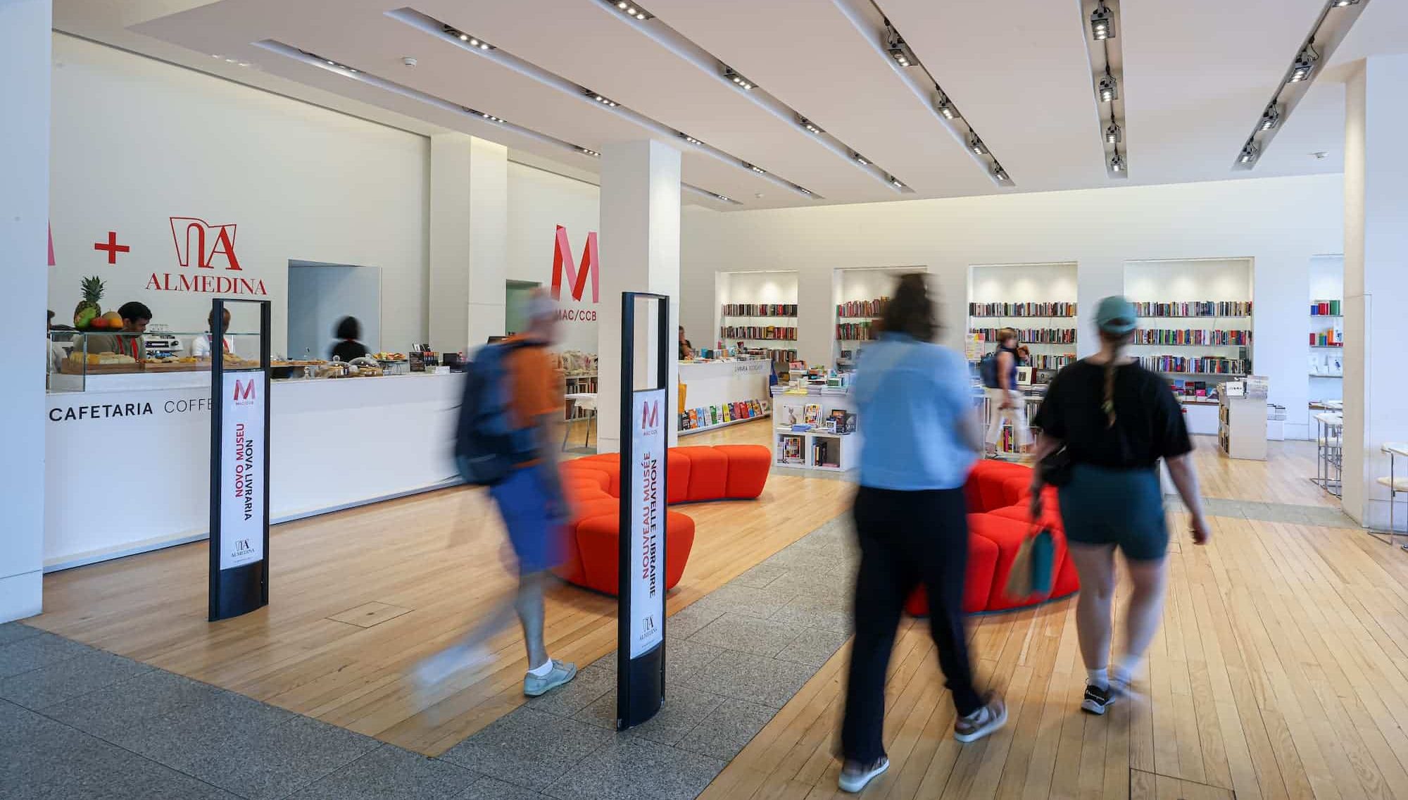 http://recepção%20da%20livraria/cafetaria%20almedina%20com%20balcão%20de%20atendimento,%20paredes%20brancas,%20prateleiras%20com%20livros%20e%20cadeiras%20confortáveis%20na%20área%20de%20espera.%20Pessoas%20entram%20e%20saem,%20criando%20uma%20atmosfera%20acolhedora%20e%20eficiente.